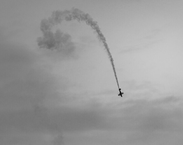 Фото Низкоугольный вид самолета, летящего против неба