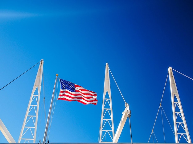 Фото Низкоугольный вид американского флага на олимпийском овале в юте на фоне чистого голубого неба