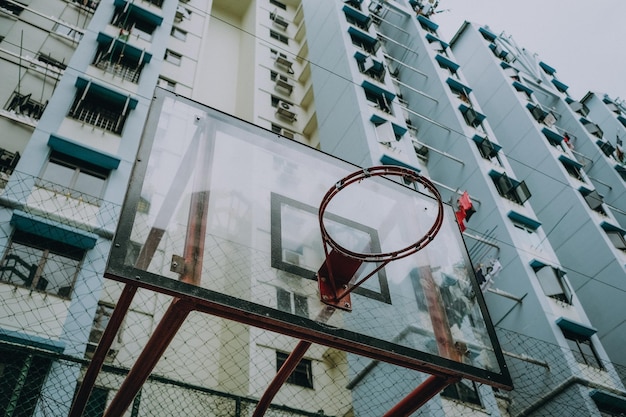 Фото Низкоугольный вид баскетбольного кольца на здания