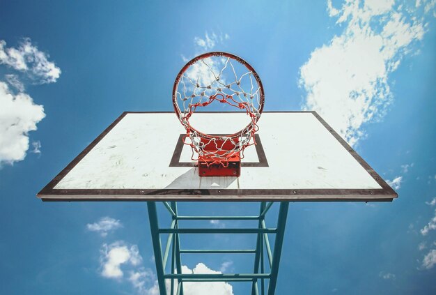 写真 空に照らされたバスケットボールホープの低角度の眺め