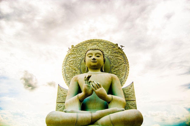 写真 雲を背景にした仏像の低角度の眺め