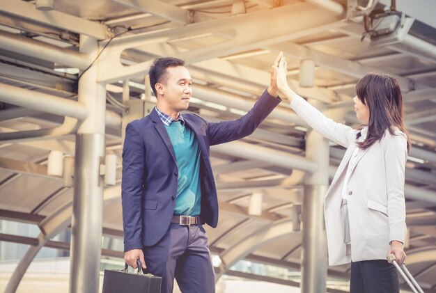 写真 天井にハイファイブをしているビジネスマンたちの低角度の景色