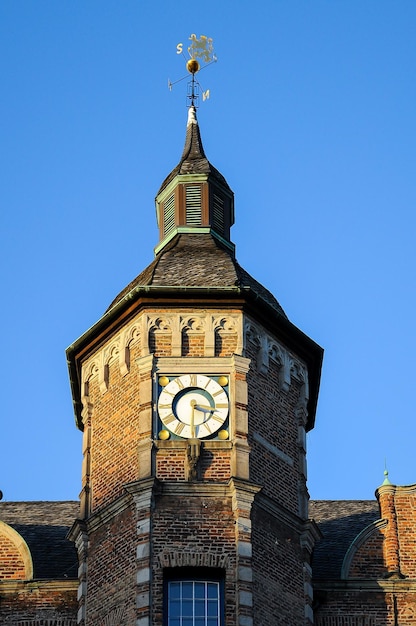 Фото Низкоугольный вид башни с часами на фоне ясного голубого неба