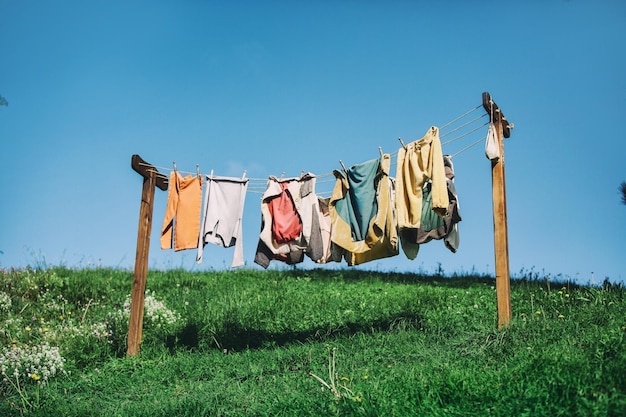 写真 空に逆らって衣料のラインで乾燥する服の低角度の景色