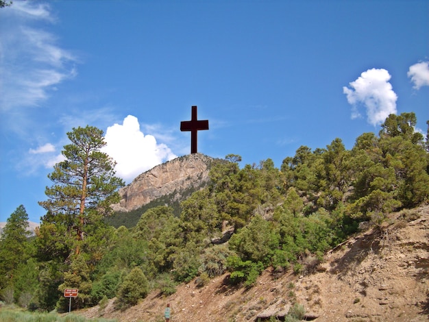 Фото Низкоугольный вид креста на деревянной горе на фоне неба