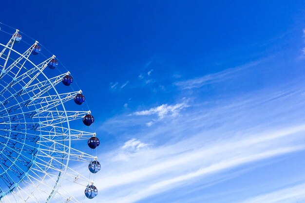 写真 青い空を背景にしたフェリスホイールの低角度の景色