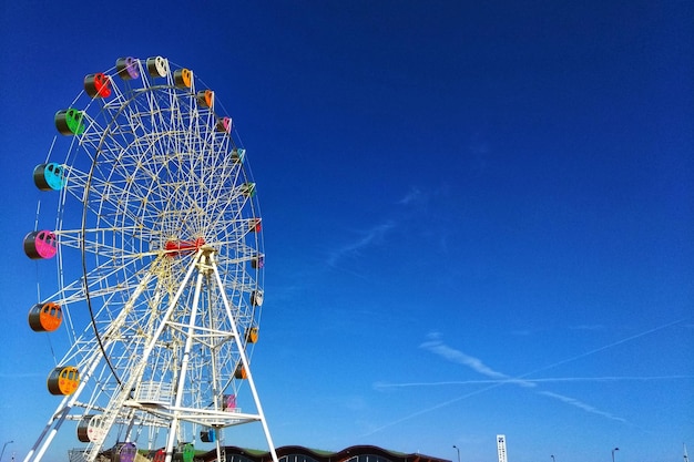 写真 澄んだ青い空を背景にしたフェリスホイールの低角度の景色