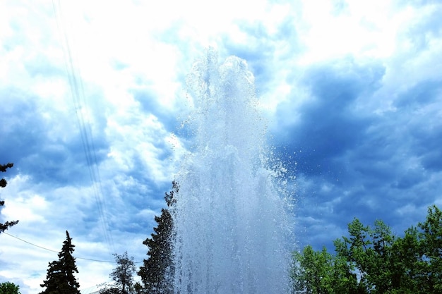 写真 雲の空を背景にした噴水の低角度の景色