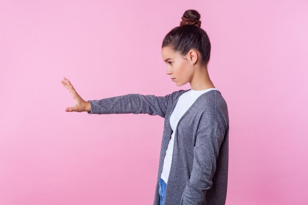 写真 ピンクの背景に立っている女の子の低角度の視点