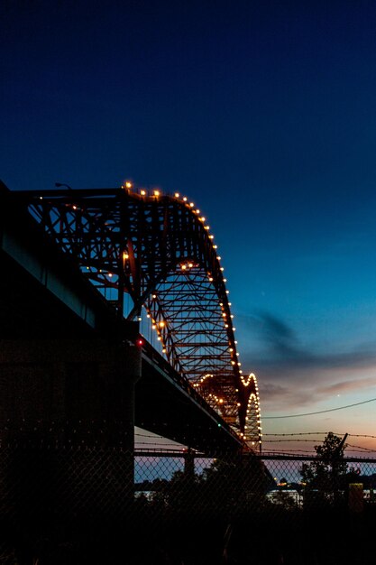 Фото Низкоугольный вид освещенного консольного моста на небе
