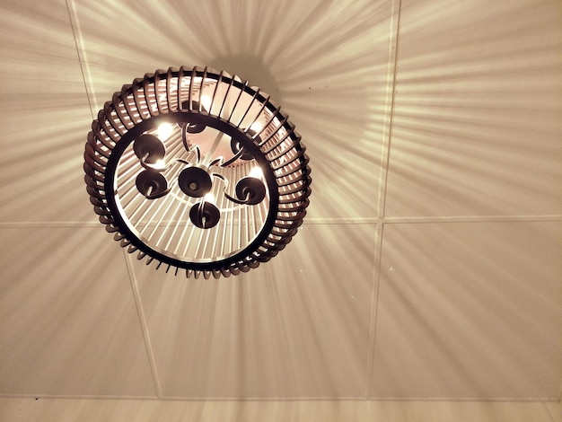 Фото Низкоугольный вид освещенной люстры, висящей с потолка