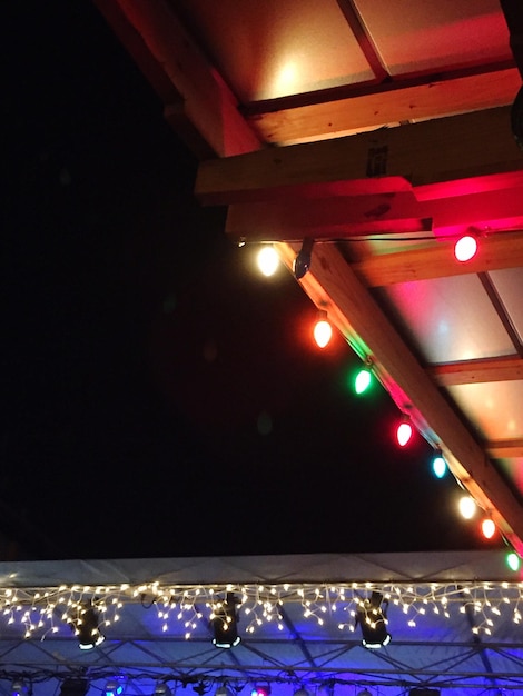 写真 夜の空に照らされた屋根の照明装飾の低角度のビュー