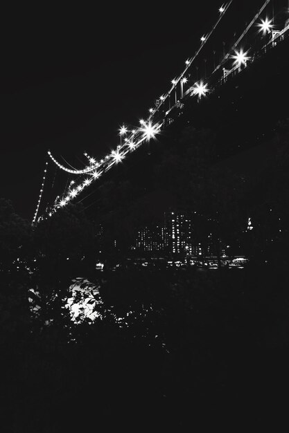 Фото Низкоугольный вид освещенного манхэттенского моста ночью