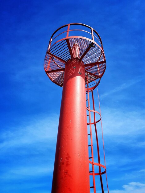 写真 青い空に照らされた灯台の低角度の景色