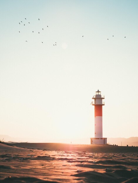 写真 夕暮れの空に照らされた灯台の低角度の景色