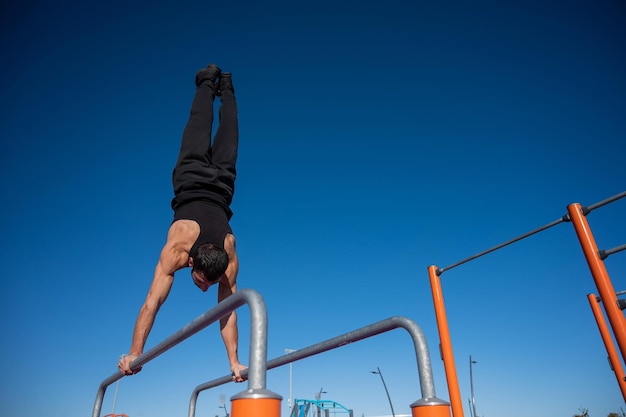 写真 明るい青い空を背景に野原に登っている男の低角度の写真