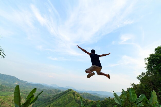 写真 空に向かってジャンプする男の低角度の景色