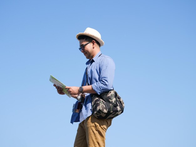 写真 青い空を背景に立っている男の低角度の景色