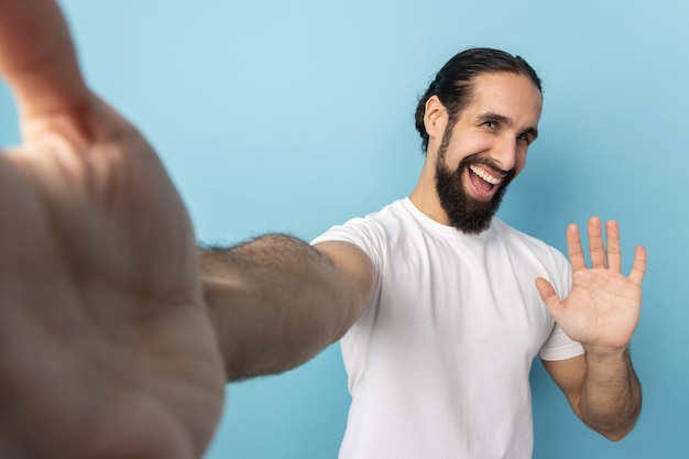 写真 明るい空を背景に腕を交差させた男の低角度の写真