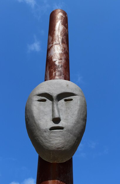 写真 晴れた日,青い空を背景に金属の柱の上にあるマスクの低角度のビュー