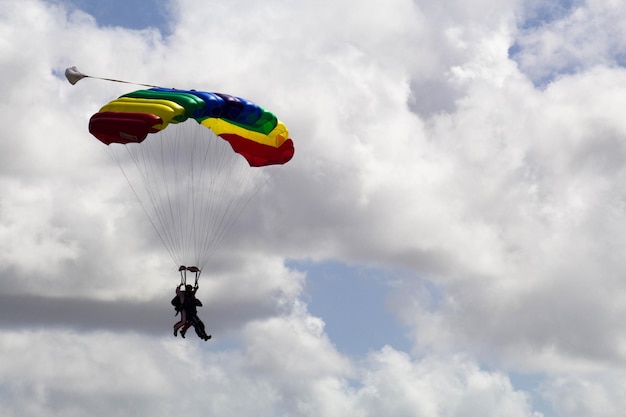 写真 空に向かってパラグライディングをしている男性の低角度の写真