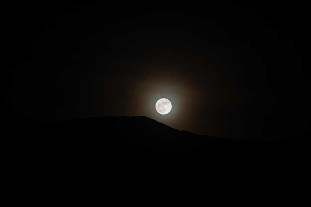 写真 夜空の背景に月を低角度で眺める