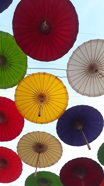 写真 空にぶら下がっている多色の傘の低角度の眺め