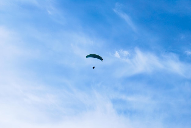 Фото Низкоугольный вид человека, катающегося на параплане против неба