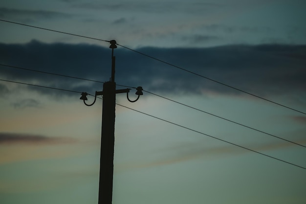 写真 空に照らされたシルエット電気柱の低角度のビュー