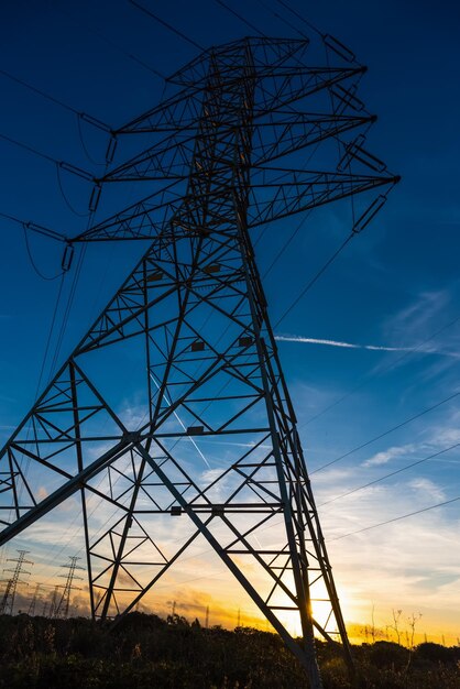 写真 空に照らされたシルエット電気柱の低角度のビュー