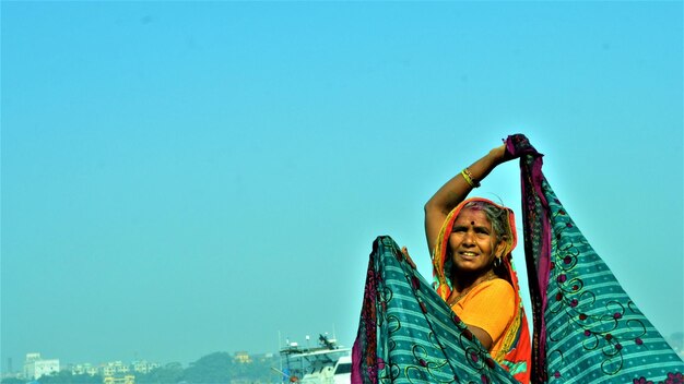 写真 晴れた空を背景に微笑む女性の低角度の景色