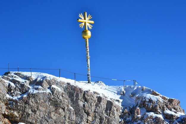 写真 青い空を背景に雪に覆われた山の低角度の景色