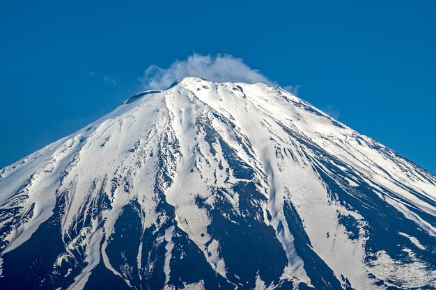 写真 青い空を背景に雪に覆われた山の低角度の景色