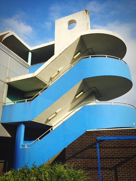 Фото Низкоугольный вид лестницы в здании на небо