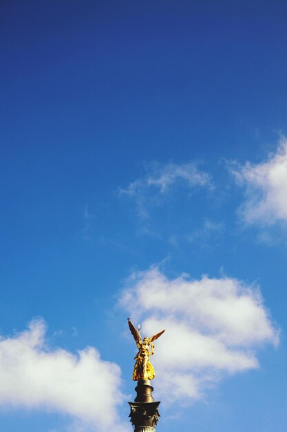 Фото Низкоугольный вид статуи на облачном небе
