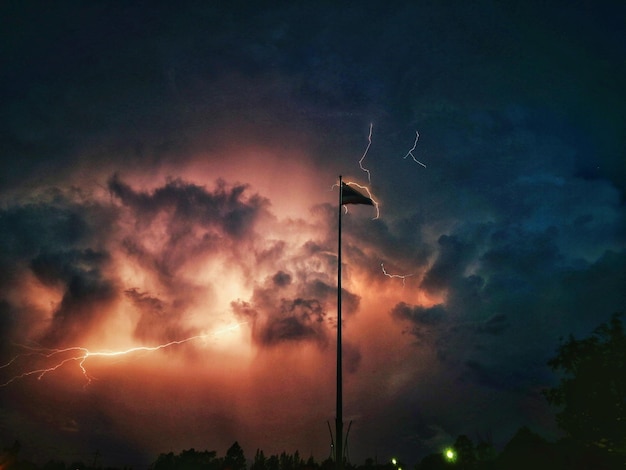 Фото Низкоугольный вид уличного освещения на фоне драматического неба