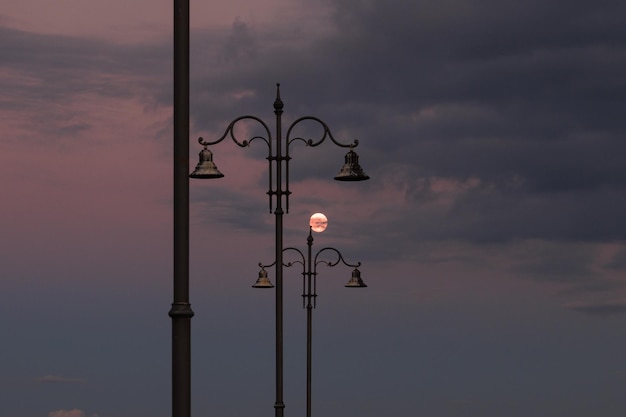 사진 달이 뜨는 동안 하늘을 배경으로 거리 불빛의 낮은 각도 시각
