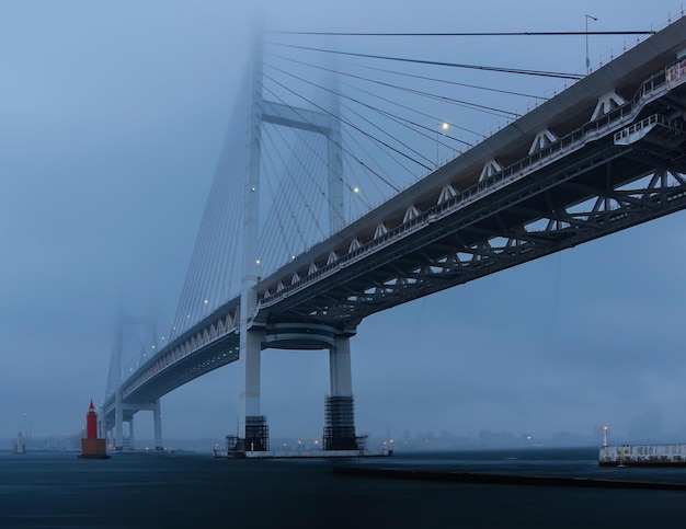 Фото Низкоугольный вид подвесного моста на небо в туманное утро в йокогаме, япония