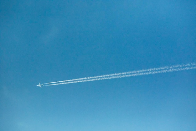 写真 青い空を背景にした蒸気の足跡の低角度の眺め