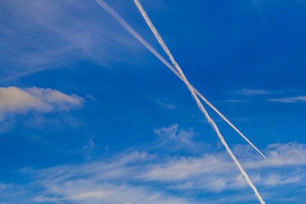 写真 青い空を背景にした蒸気の足跡の低角度の眺め