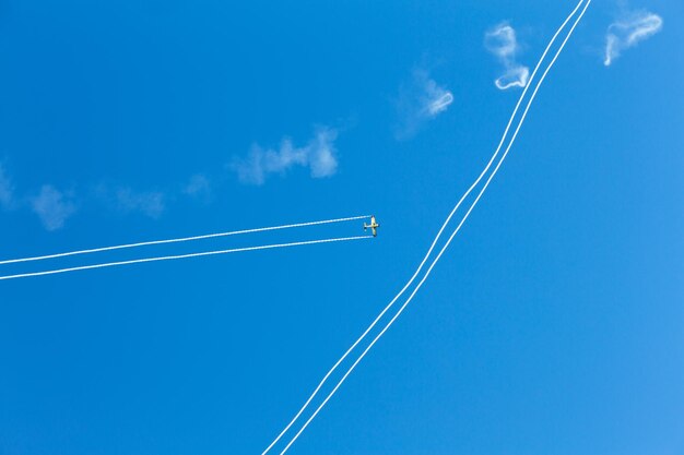 写真 青い空を背景にした蒸気の足跡の低角度の眺め
