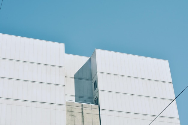 写真 明るい青い空の背景に白い建物の低角度の景色