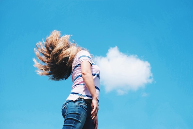 Фото Низкий угол зрения женщины, стоящей на синем небе