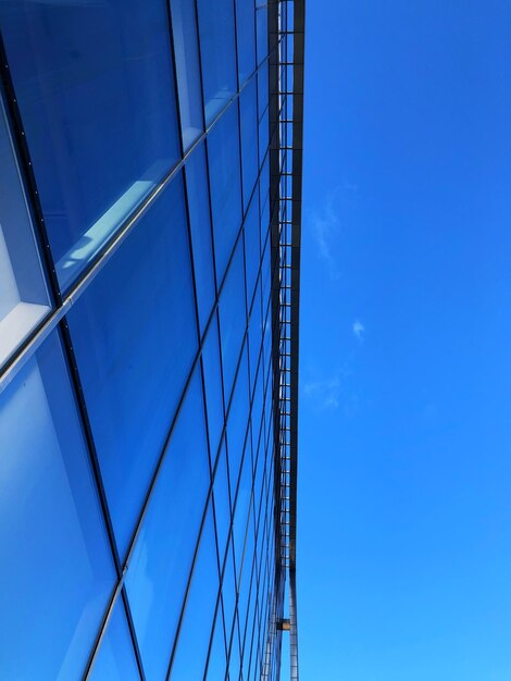 Low angle view of an office building against clear blue sky