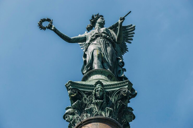 Photo low angle view of old angel statue against blue sky at charlottenburg palace