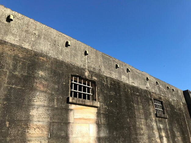 Low angle view of old building against clear blue sky