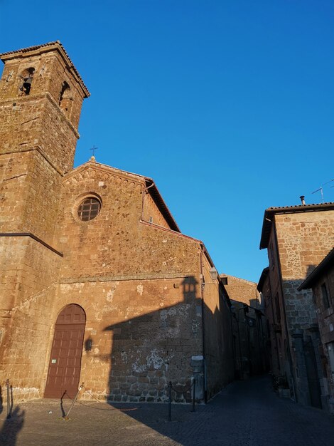 Low angle view of old building against clear blue sky