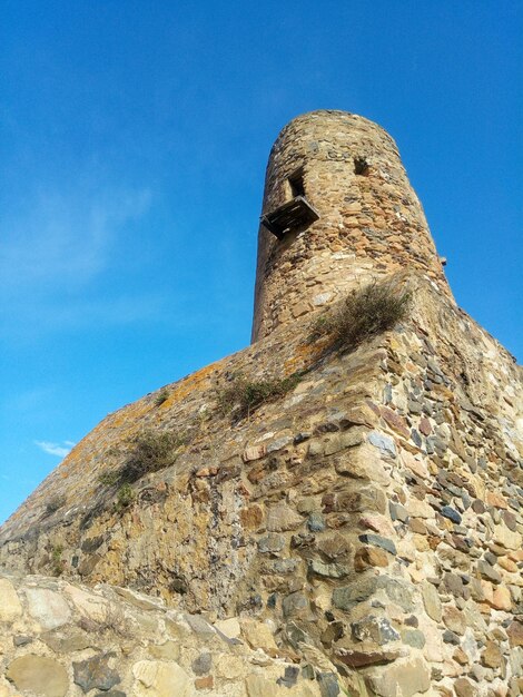 Low angle view of old ruins against clear blue sky