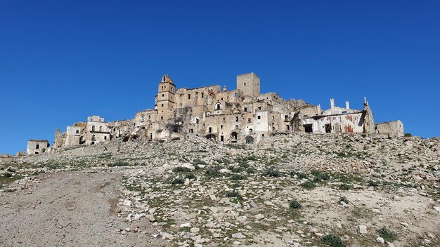 Low angle view of old ruins against clear blue sky