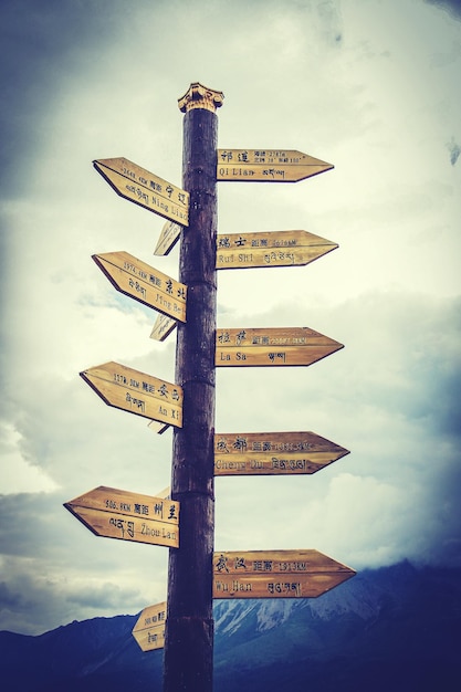 Photo low angle view of old wooden sign board against sky